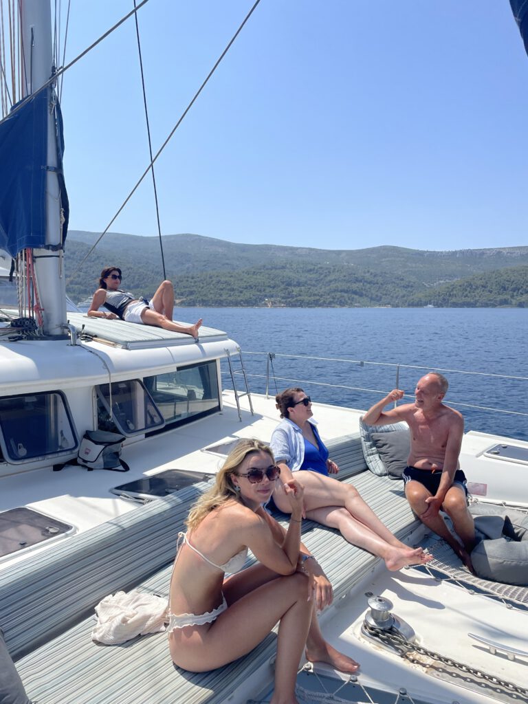 Entspannte Gäste genießen die Zeit an Deck des Katamarans