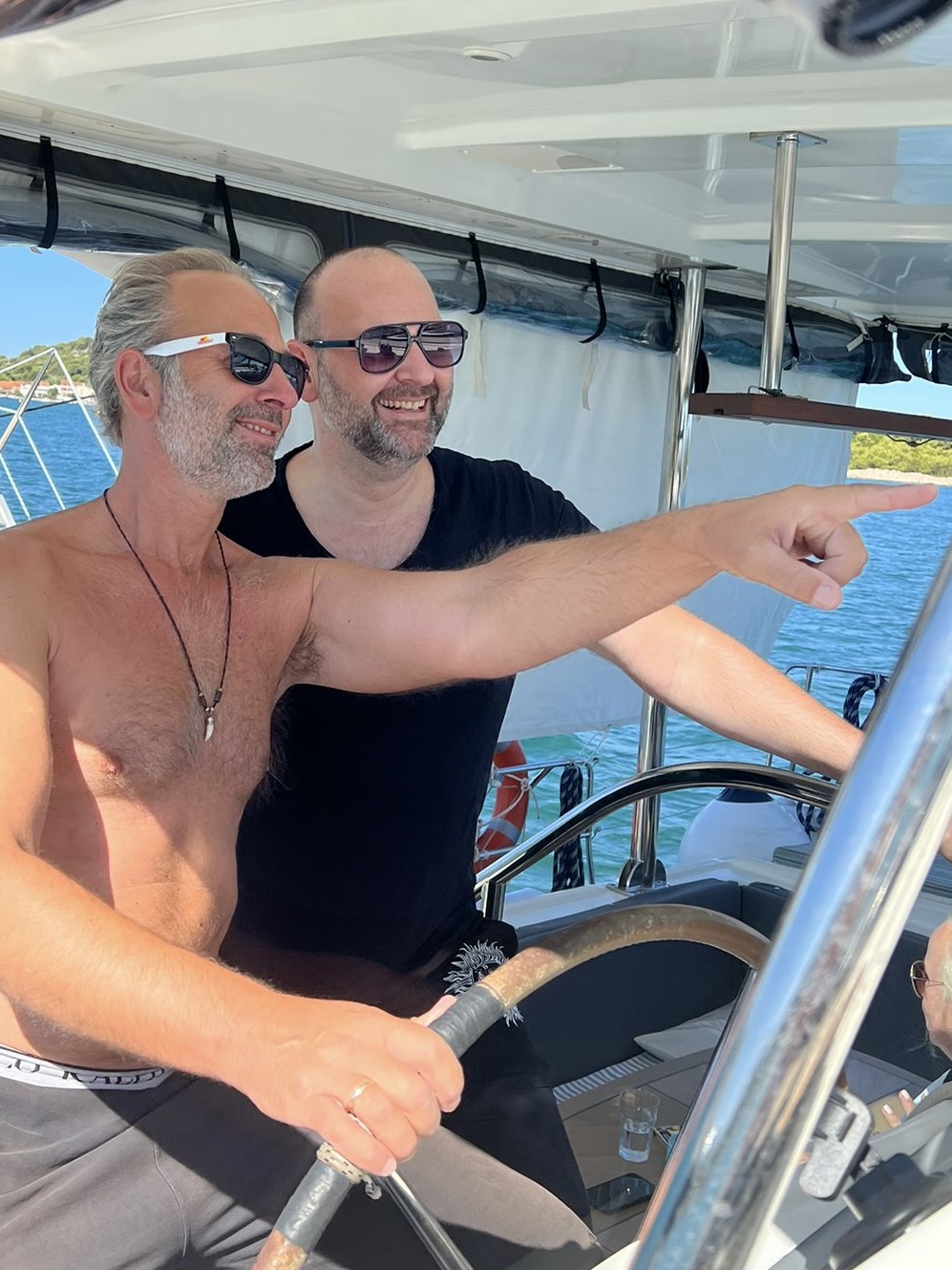 Markus and a guest at the helm of the catamaran
